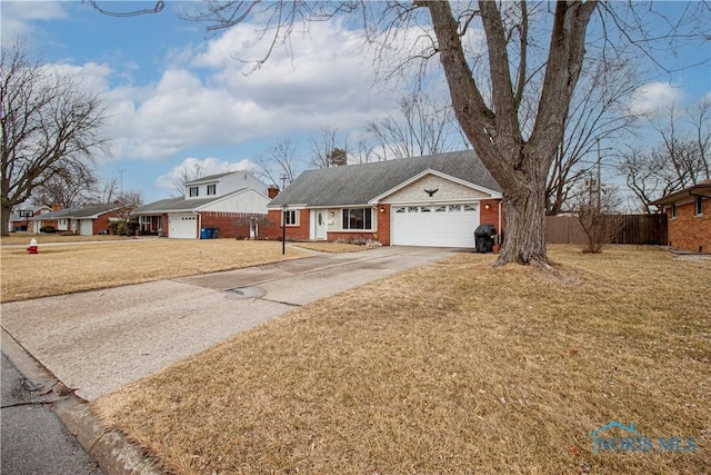 ranch-style home featuring a garage, brick siding, fence, driveway, and a front yard