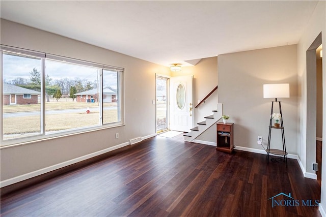 empty room featuring visible vents, stairs, baseboards, and wood finished floors