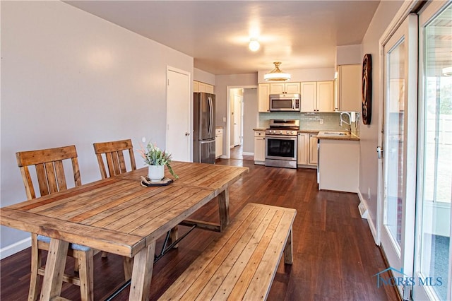 dining area featuring dark wood finished floors and baseboards