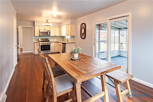 dining area featuring dark wood-type flooring and baseboards