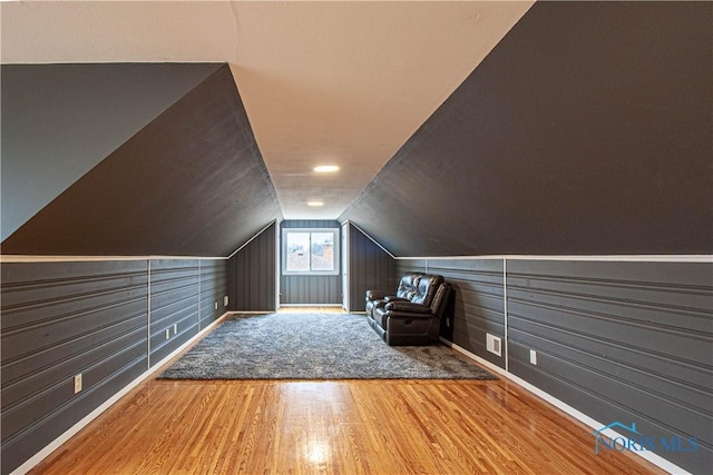 additional living space with lofted ceiling, visible vents, and wood finished floors