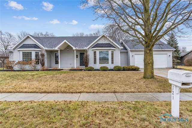 single story home featuring a garage, concrete driveway, and a front yard