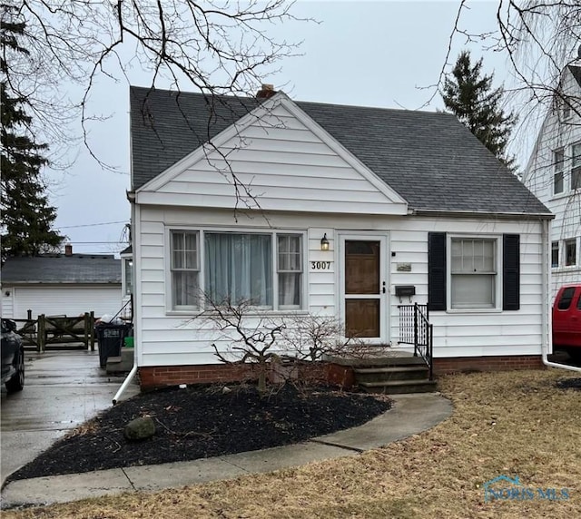 bungalow-style house with roof with shingles