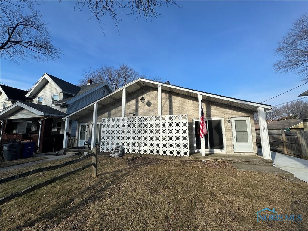 view of front of home with brick siding and fence