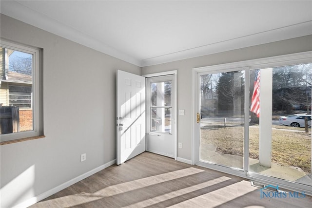 interior space with baseboards and wood finished floors