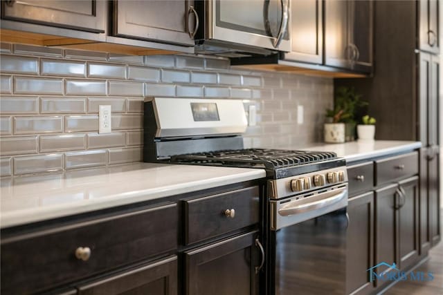 kitchen with appliances with stainless steel finishes, light countertops, dark brown cabinetry, and backsplash