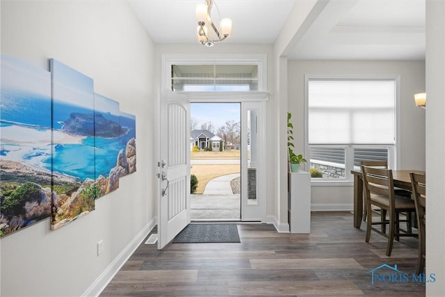 foyer with wood finished floors, a wealth of natural light, and baseboards