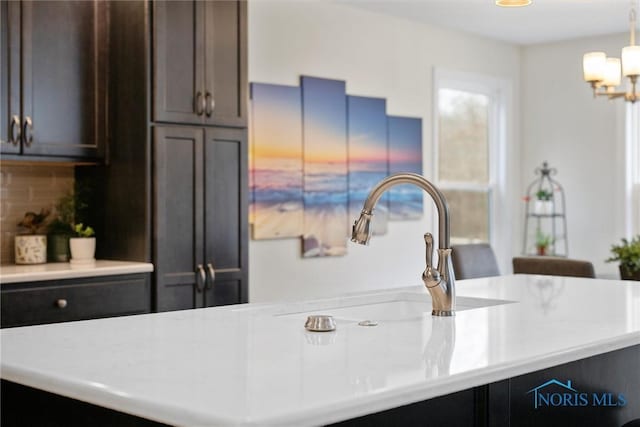 kitchen featuring light countertops, a sink, and pendant lighting