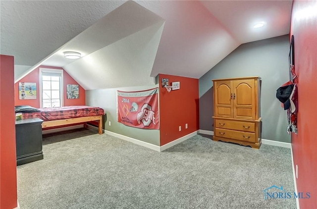 carpeted bedroom with vaulted ceiling, a textured ceiling, and baseboards