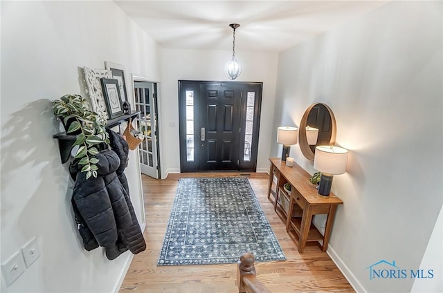 foyer with baseboards and light wood finished floors