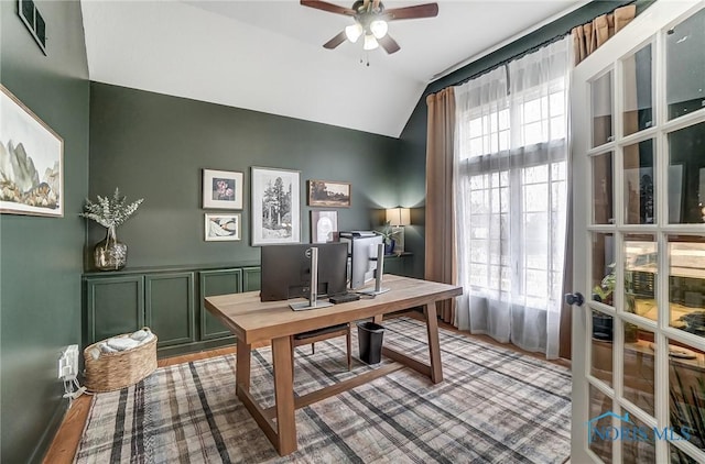 home office with lofted ceiling, ceiling fan, plenty of natural light, and visible vents