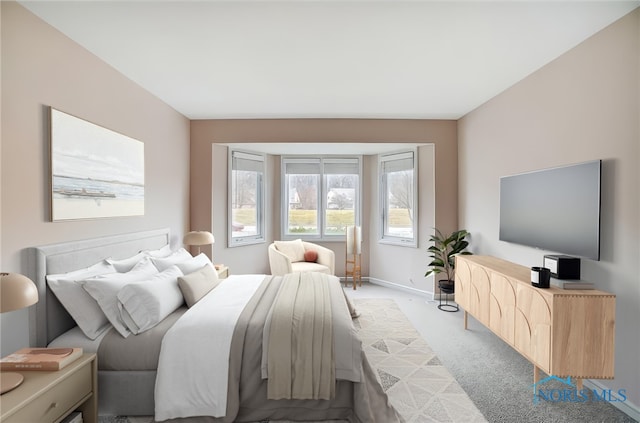 bedroom featuring light colored carpet and baseboards