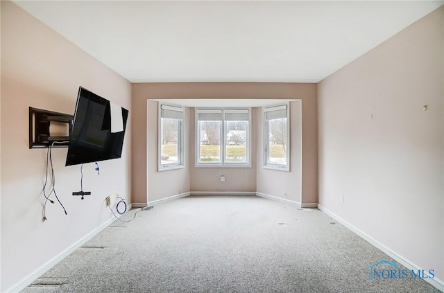 unfurnished living room with carpet and baseboards