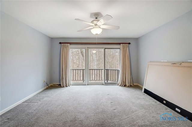 carpeted empty room with ceiling fan and baseboards