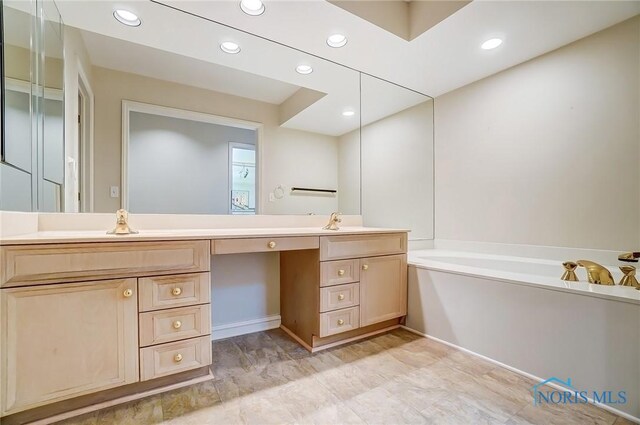 bathroom with recessed lighting, a bath, and vanity