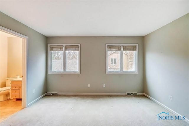 interior space with carpet floors, multiple windows, and visible vents