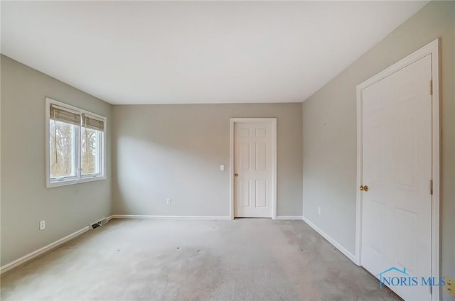 carpeted empty room featuring visible vents and baseboards