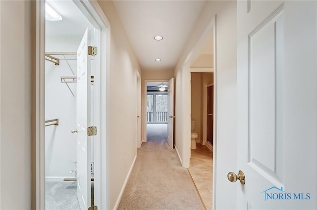 hallway featuring recessed lighting, baseboards, and light colored carpet