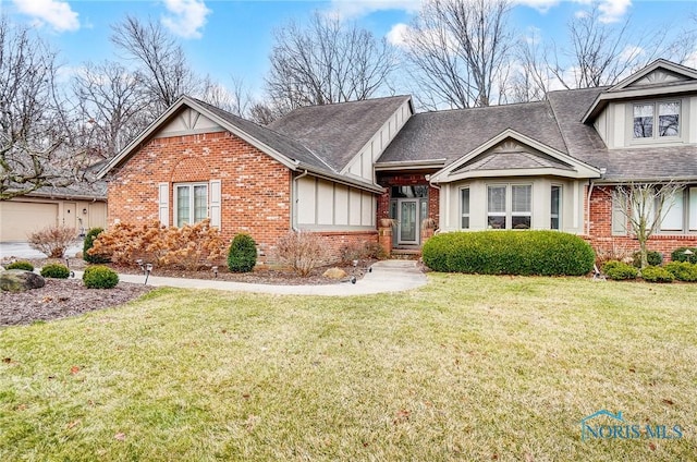 view of front of property featuring a shingled roof, a front lawn, and brick siding