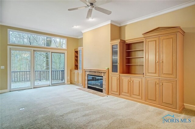 unfurnished living room with light carpet, ornamental molding, a fireplace with flush hearth, and baseboards