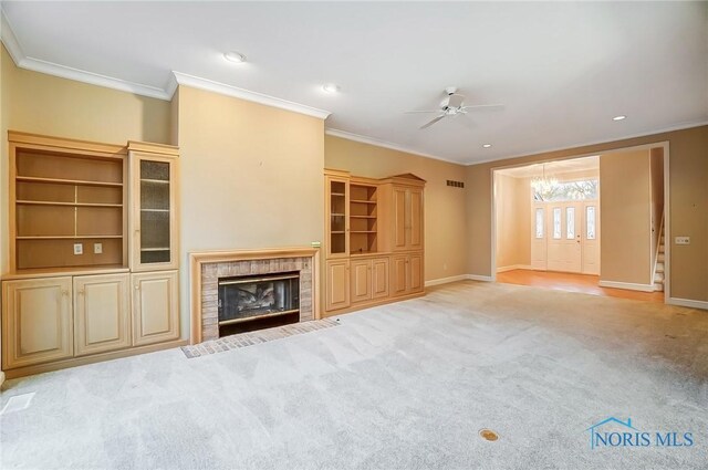 unfurnished living room featuring ornamental molding, carpet, a tile fireplace, and baseboards