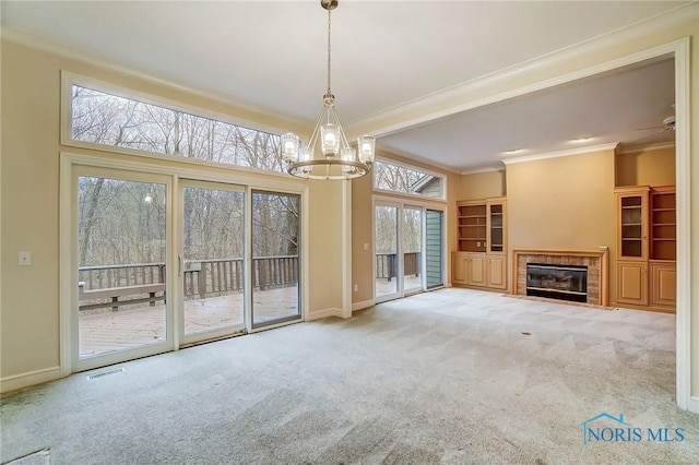 unfurnished living room with carpet floors, a tile fireplace, visible vents, and baseboards