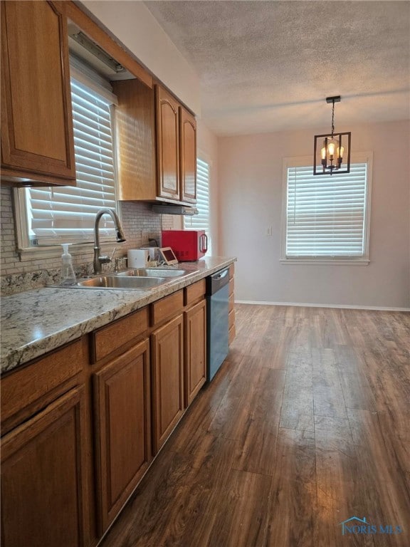 kitchen with a sink, stainless steel dishwasher, tasteful backsplash, brown cabinetry, and dark wood finished floors