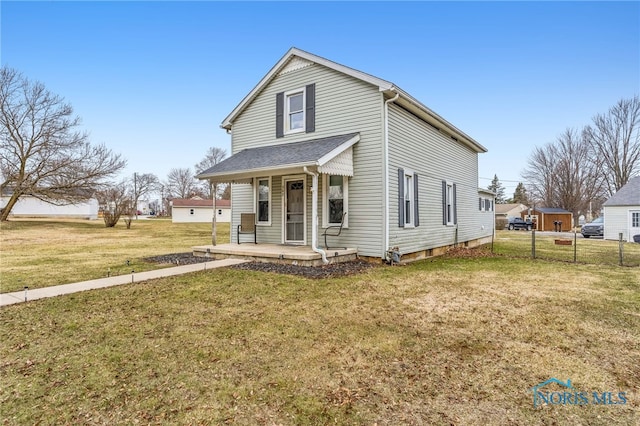 view of front facade with covered porch, a front yard, and fence