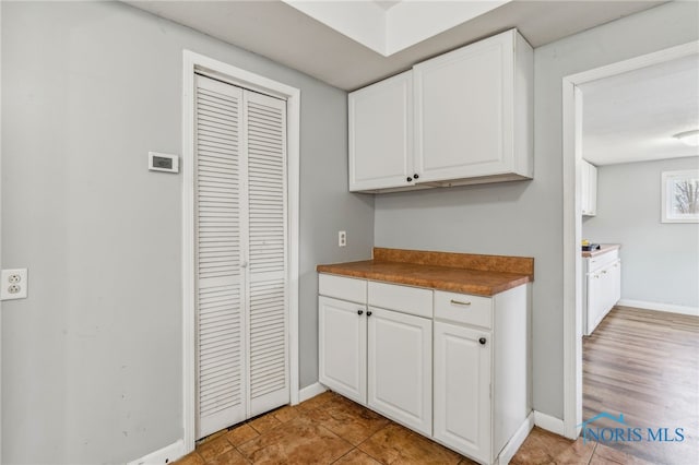 kitchen with white cabinetry and baseboards