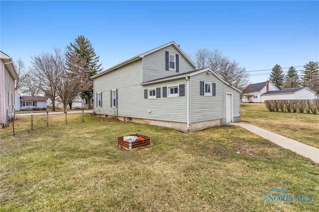 back of house featuring a lawn and fence