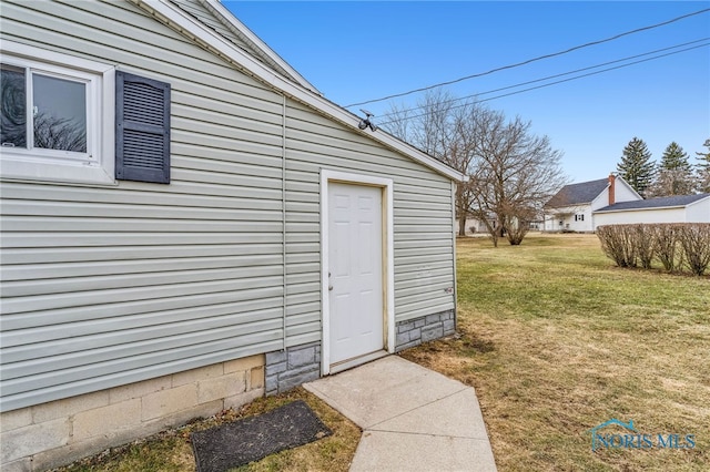 view of exterior entry featuring a yard