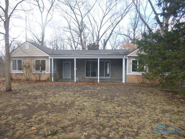 single story home featuring covered porch, a chimney, and brick siding