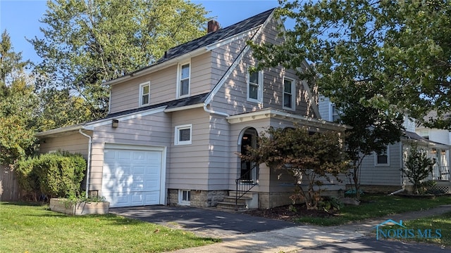 view of front of property featuring an attached garage, a chimney, and a front lawn