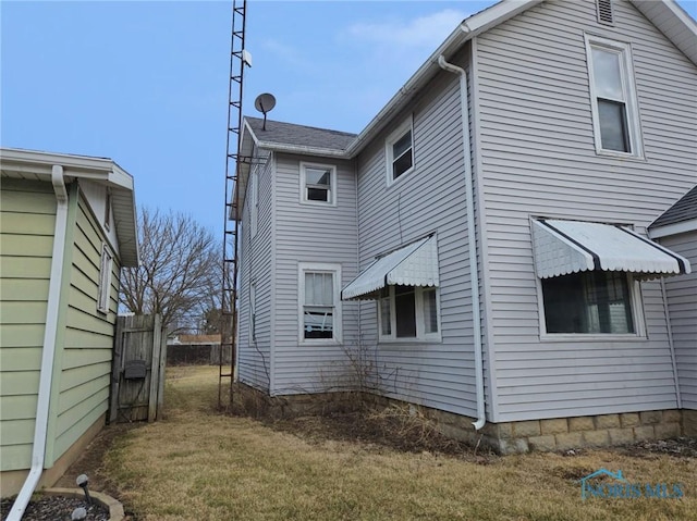 view of side of home with a yard