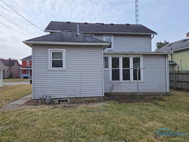 back of property featuring a yard and fence