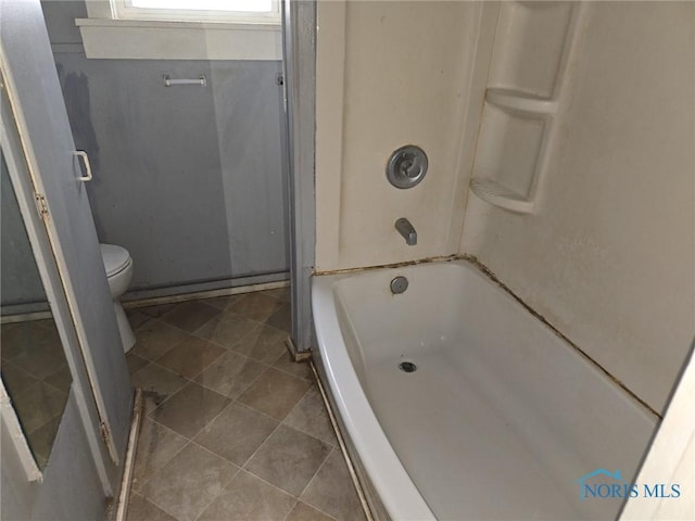 full bath with toilet, tile patterned flooring, and tub / shower combination