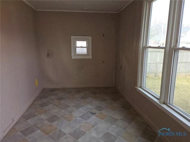 unfurnished room featuring crown molding and baseboards