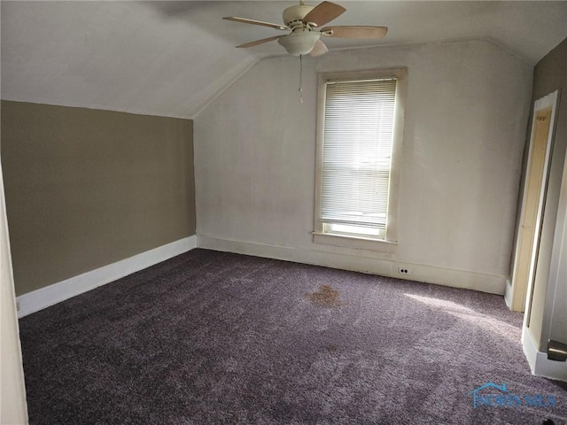 bonus room with a ceiling fan, vaulted ceiling, dark carpet, and baseboards