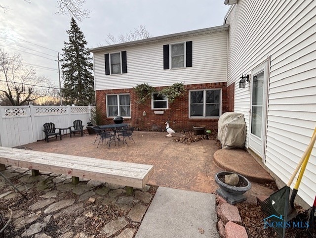 back of property featuring a patio, brick siding, and fence