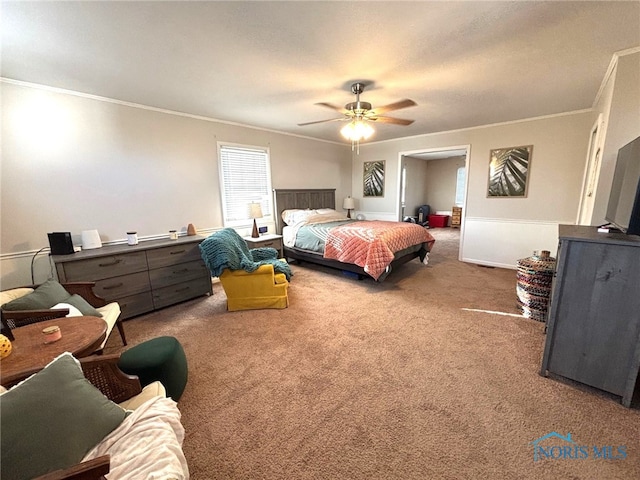 carpeted bedroom featuring ceiling fan, baseboards, and ornamental molding