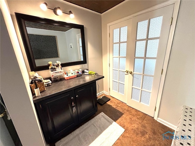 bathroom featuring vanity, french doors, and baseboards