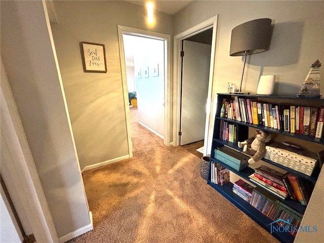 corridor featuring baseboards and carpet floors