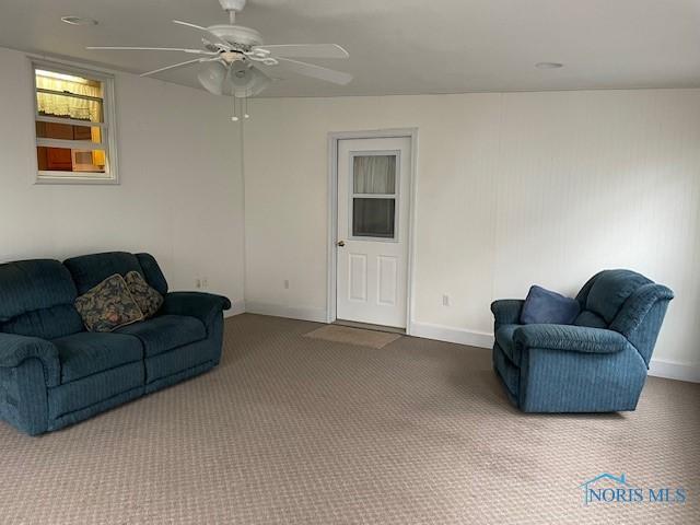 living room with a ceiling fan, baseboards, and carpet floors