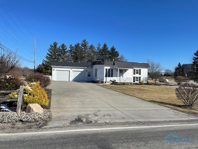 ranch-style home with a front yard, a garage, and driveway