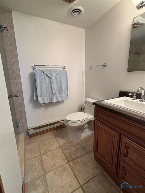 bathroom featuring toilet, visible vents, vanity, tiled shower, and tile patterned floors