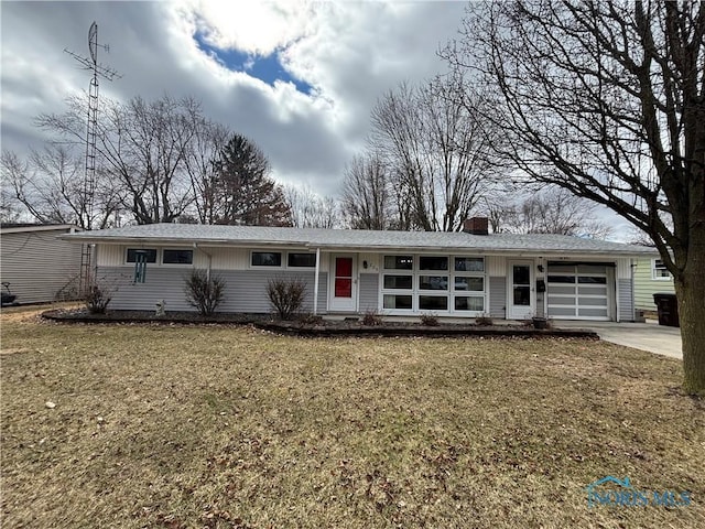 view of front of home featuring a garage, a chimney, a front lawn, and concrete driveway