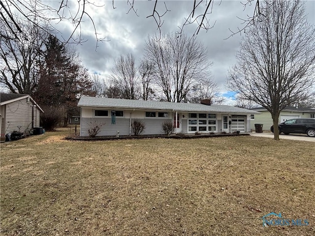 single story home featuring a garage, a chimney, and a front yard