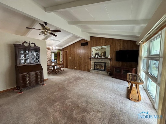 living area featuring visible vents, lofted ceiling with beams, carpet flooring, a stone fireplace, and wood walls