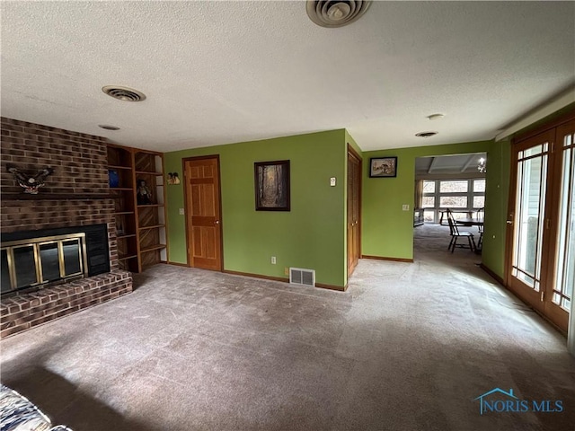 unfurnished living room with visible vents, a fireplace, and a textured ceiling