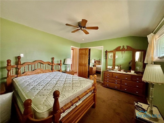 bedroom with ceiling fan, dark colored carpet, and a closet